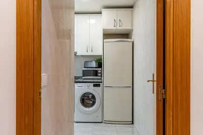 a kitchen with a refrigerator and a washing machine at Canela Homes BARCELONA ARC DE TRIOMF in Barcelona