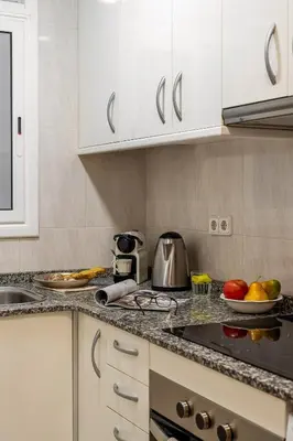 a kitchen with white cabinets and fruits on the counter at Canela Homes BARCELONA ARC DE TRIOMF in Barcelona