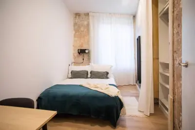 a bedroom with a bed with a green blanket on it at 12Ara1093- New & Spacious 3BR Flat in Barcelona