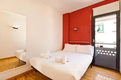 a bedroom with a white bed with a red wall at Stay U-nique Apartments Bonsoms in Barcelona
