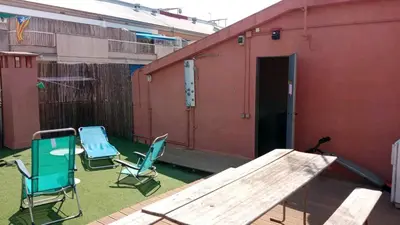 a patio with two chairs and a table and a building at Stay U-nique Apartments Bonsoms in Barcelona