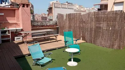 a patio with chairs and a table on a roof at Stay U-nique Apartments Bonsoms in Barcelona