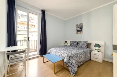 a bedroom with a bed and a desk and a window at Habitación 1 NOU DE LA RAMBLA in Barcelona