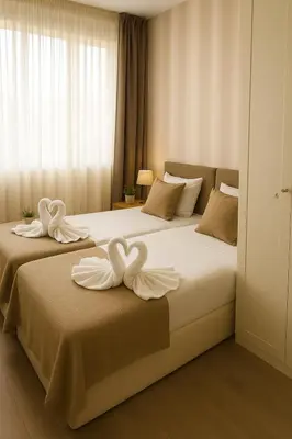 two beds in a hotel room with white towels on them at Luz y Mar II in Barcelona