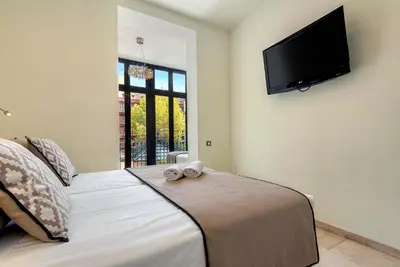 a bedroom with a bed with a flat screen tv on the wall at Limonaia in Barcelona