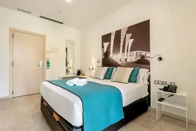 a bedroom with a large bed with a blue blanket at Limonaia in Barcelona