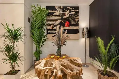 a room with potted plants and a table in the middle at Limonaia in Barcelona