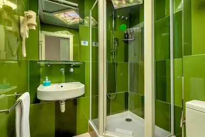a green bathroom with a sink and a shower at Limonaia in Barcelona