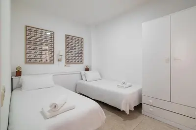 two beds in a room with white walls at Stay U-nique Apartment Creu Coberta II in Barcelona