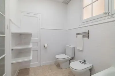 a white bathroom with a toilet and a sink at Stay U-nique Apartment Creu Coberta II in Barcelona
