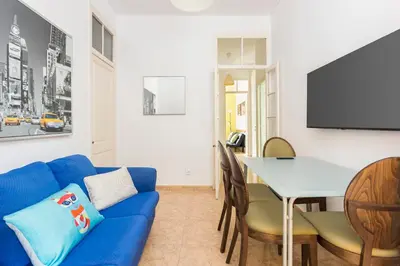 a living room with a blue couch and a table at Apartament Clot 2 in Barcelona