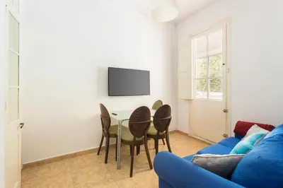a living room with a blue couch and a table and chairs at Apartament Clot 2 in Barcelona