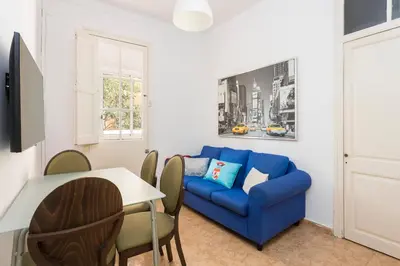 a living room with a blue couch and a table at Apartament Clot 2 in Barcelona
