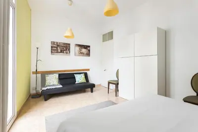 a bedroom with a bed and a couch and a table at Apartament Clot 2 in Barcelona
