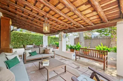 an outdoor patio with a wooden pergola at Casa Alba Garden & Calm in Sitges