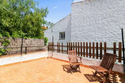 two chairs sitting on a patio with a fence at Casa Alba Garden & Calm in Sitges