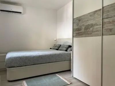 a small bedroom with a bed and a mirror at Apartamento con jardín cerca playa y a 15 min de Plaza Catalunya en tren in Sant Adria de Besos