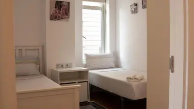 a small room with two beds and a window at Cathedral Charm on Via Lantana in Barcelona