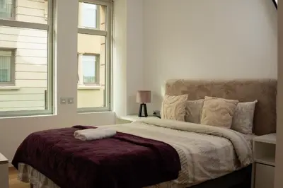 a bed in a room with two windows at Cathedral Charm on Via Lantana in Barcelona