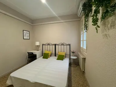 a bedroom with a large white bed with green pillows at Gran Via Green in Barcelona