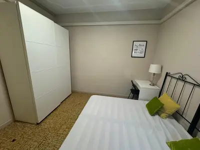a small bedroom with a bed and a desk at Gran Via Green in Barcelona