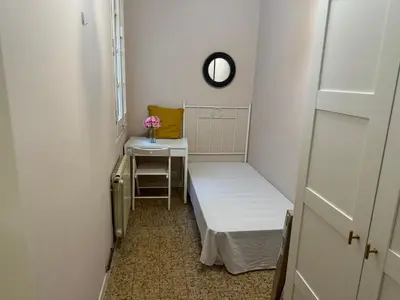a small room with a bed and a table and a mirror at Gran Via Green in Barcelona