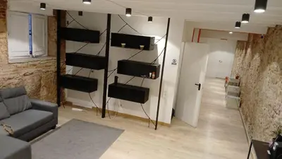 a living room with a couch and a wall with speakers at Ink House in Barcelona