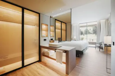 a bedroom with a bed and a sink and a mirror at Hotel Món Sant Benet in Sant Fruitos de Bages