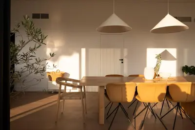 a dining room with a wooden table and chairs at Infinity House in Cabrera de Mar