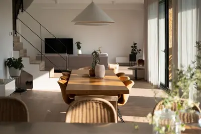 a living room with a wooden table and chairs at Infinity House in Cabrera de Mar