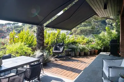 a patio with tables and chairs and plants at Infinity House in Cabrera de Mar