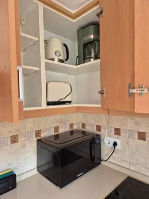 a kitchen with a black microwave on a counter at Gran terrassa al cantó del mar in Canet de Mar