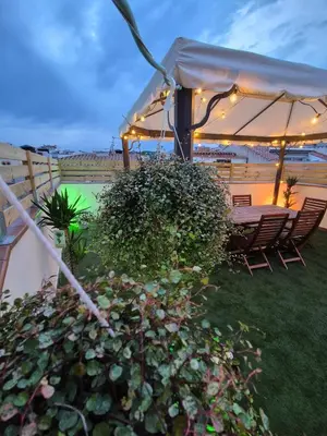a patio with a table and chairs under an umbrella at Gran terrassa al cantó del mar in Canet de Mar