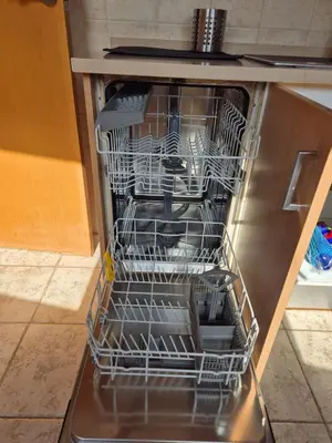 an open dishwasher with dishes in it at Gran terrassa al cantó del mar in Canet de Mar