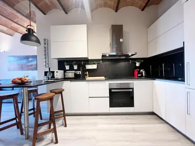 a kitchen with white cabinets and a table at Bogatell Playa Apartment in Barcelona