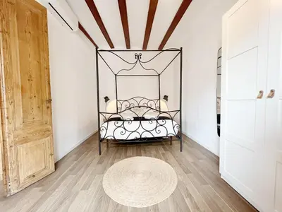 a bedroom with a bed with a wrought iron headboard at Roser Apartment in Barcelona
