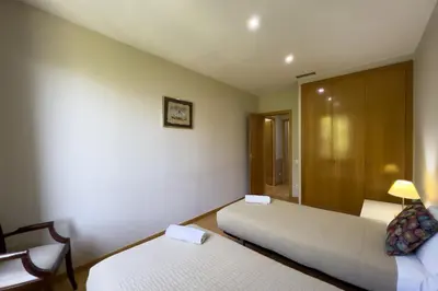 a hotel room with two beds and a chair at Gran Vía Sun in Barcelona
