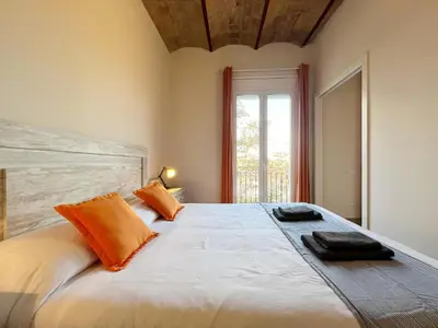 a bedroom with a large white bed with orange pillows at Pamplona Playa Apartment in Barcelona