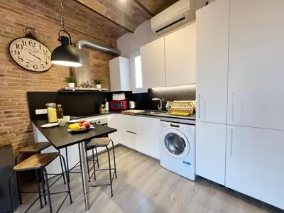 a kitchen with a table and a washing machine at Pamplona Playa Apartment in Barcelona