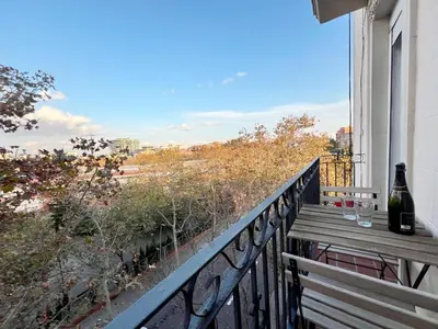 a balcony with a bottle of wine and a table on it at Pamplona Playa Apartment in Barcelona