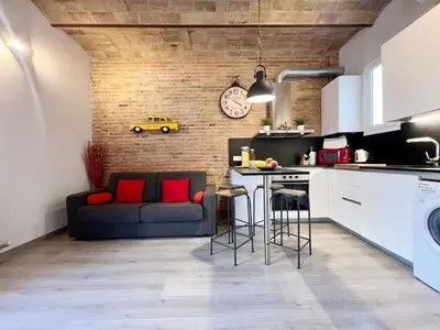 a kitchen and living room with a couch and a table at Pamplona Playa Apartment in Barcelona