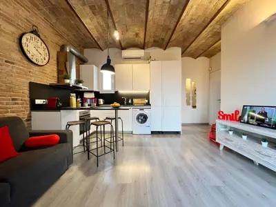 a kitchen and living room with a couch and a table at Pamplona Playa Apartment in Barcelona