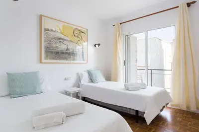 two beds in a room with a window at Stay U-nique Apartments Sitges Beach in Sitges