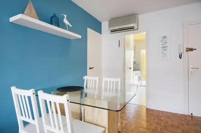 a dining room with a glass table and white chairs at Stay U-nique Apartments Sitges Beach in Sitges