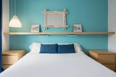 a bedroom with a large bed with blue walls at Stay U-nique Apartments Sitges Beach in Sitges