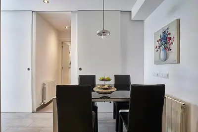a dining room with a table and black chairs at BBarcelona Brusi Flat in Barcelona
