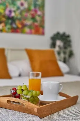 a tray with a glass of orange juice and a cup of fruit at BBarcelona Brusi Flat in Barcelona