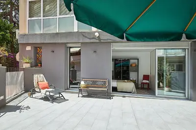 a house with a patio with a green umbrella at BBarcelona Brusi Flat in Barcelona