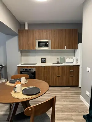 a kitchen with a wooden table and a dining room at studio Espania in Hospitalet de Llobregat