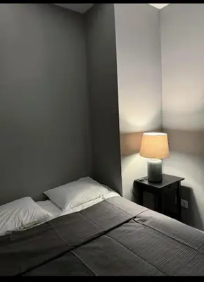 a bedroom with a bed and a table with a lamp at studio Espania in Hospitalet de Llobregat